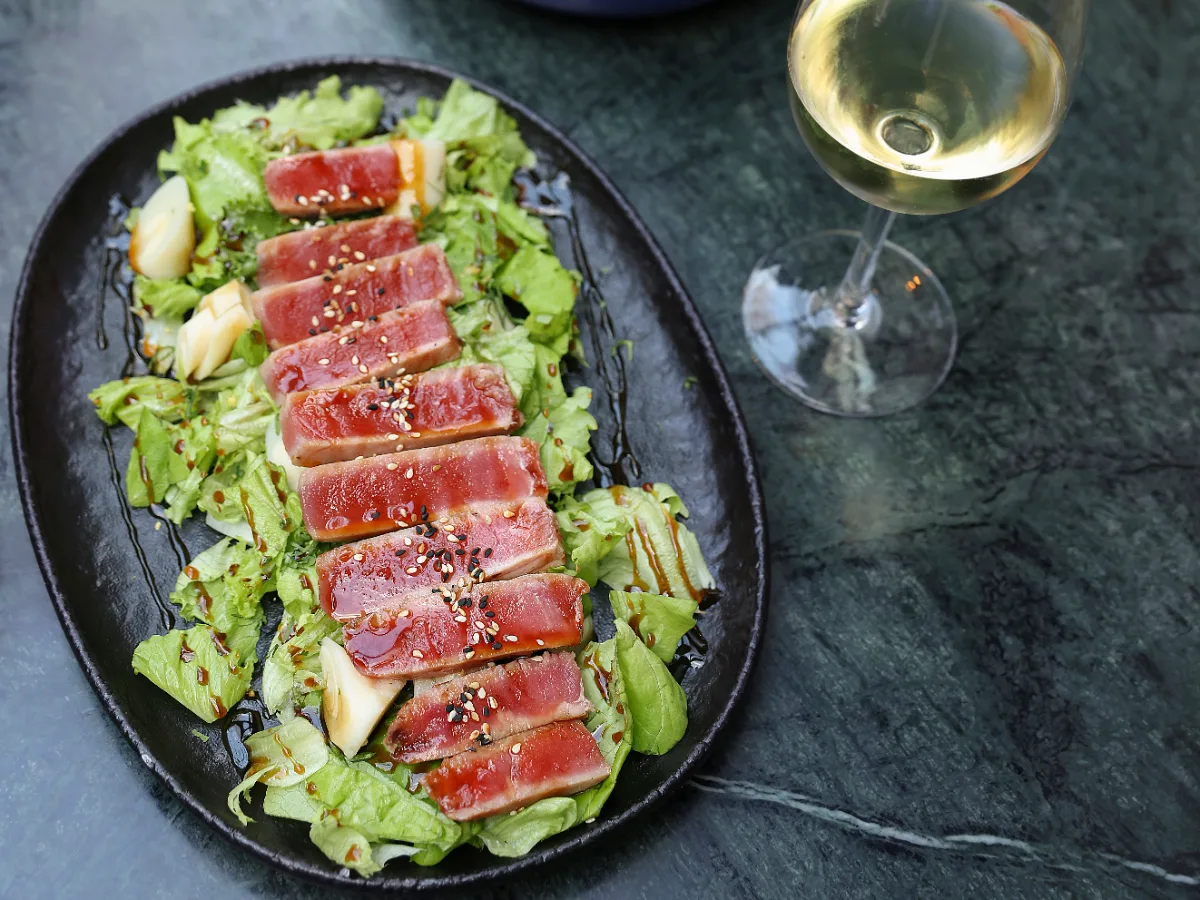 Foto de Atún plancha con salsa de sésamo sobre ensalada verde con palta, palmitos y jengibre