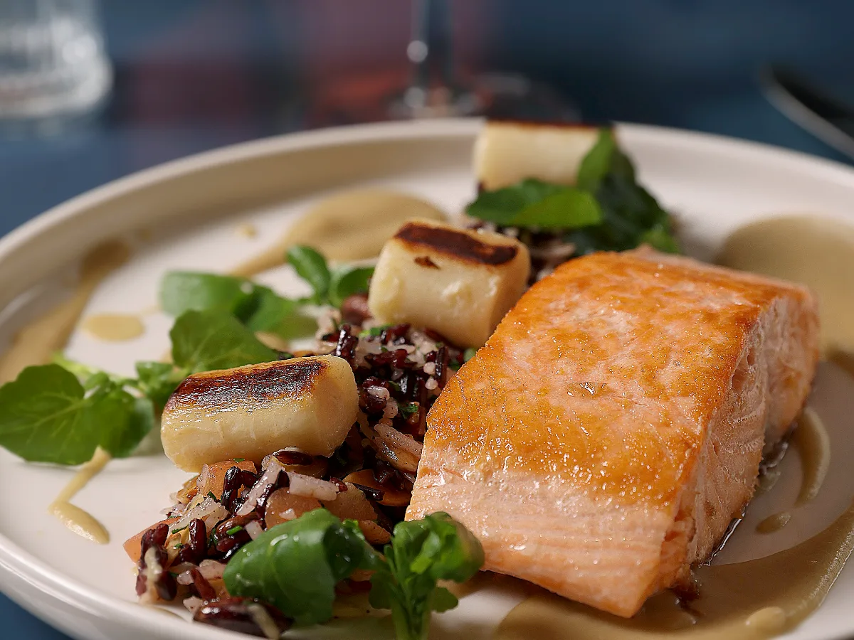 Foto de Salmón a la plancha con mix de arroces asiáticos, frutos secos, jamón serrano crocante suave salsa de berenjena y palmito ahumados